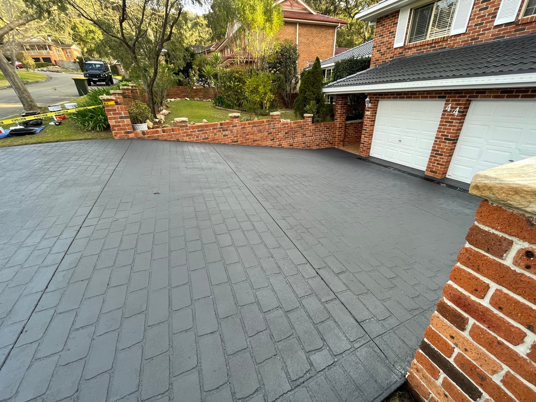A faded stencil driveway restored with a fresh charcoal colour seal